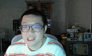 a man wearing glasses and a striped shirt is sitting in front of a tv