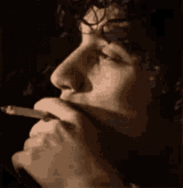 a close up of a man 's face singing into a microphone in a dark room .
