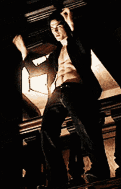 a shirtless man is standing on a balcony