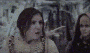 a woman with a surprised look on her face is standing next to another woman
