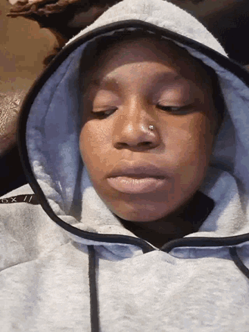 a woman wearing a gray hoodie with the letters gx on it