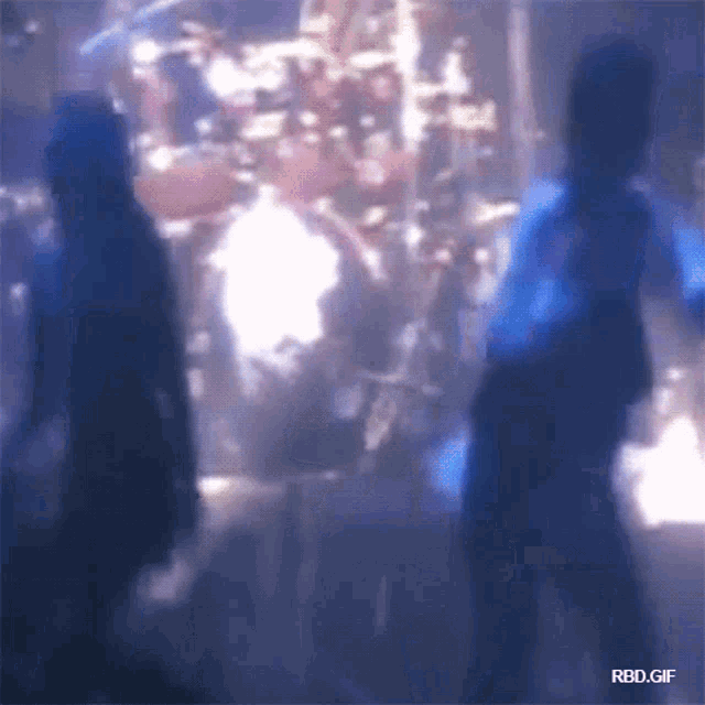 a blurry picture of a person standing in front of a drum set with the words rbd.gif at the bottom