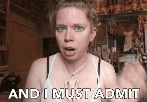 a woman says " and i must admit " in front of a doll display