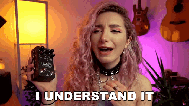 a girl with pink hair is holding a halo guitar pedal