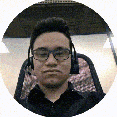 a man wearing glasses and a headset looks at the camera