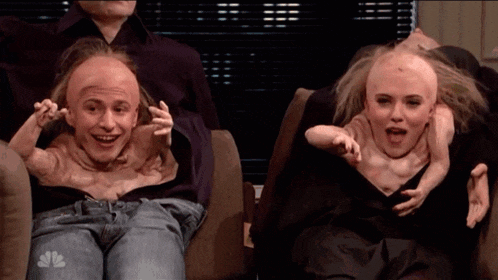 a man and a woman are sitting on a couch with their heads cut off and a snbc logo on their jeans