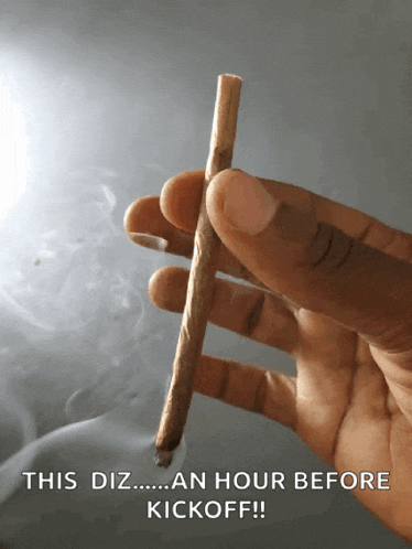 a hand holding a cigarette with the words this diz an hour before kickoff written on the bottom