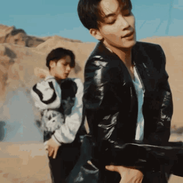 two men are standing next to each other in the desert .