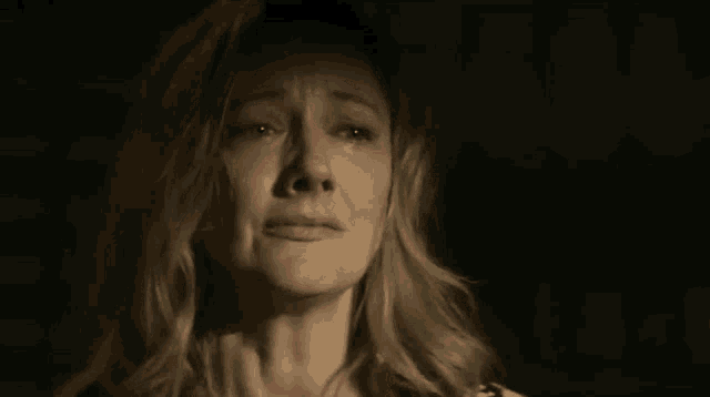 a close up of a woman 's face with her eyes closed in a dark room .