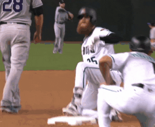 a baseball player wearing a number 15 jersey is sliding into base
