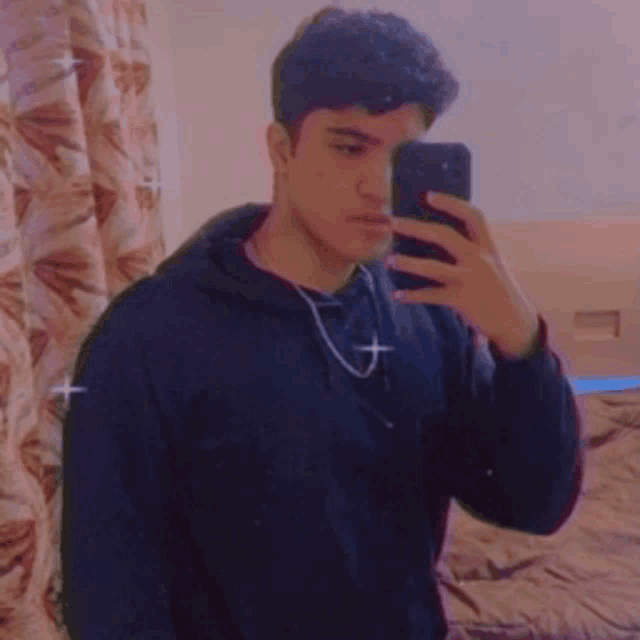a young man is taking a picture of himself in a mirror .