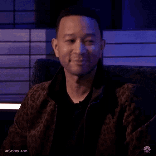 a man wearing a leopard print jacket is smiling