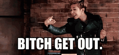 a man in a green jacket is dancing in front of a brick wall with the words bitch get out written below him