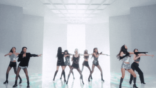 a group of women are dancing in a room with white walls