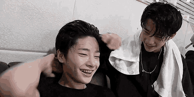 two young boys are sitting next to each other on a couch .