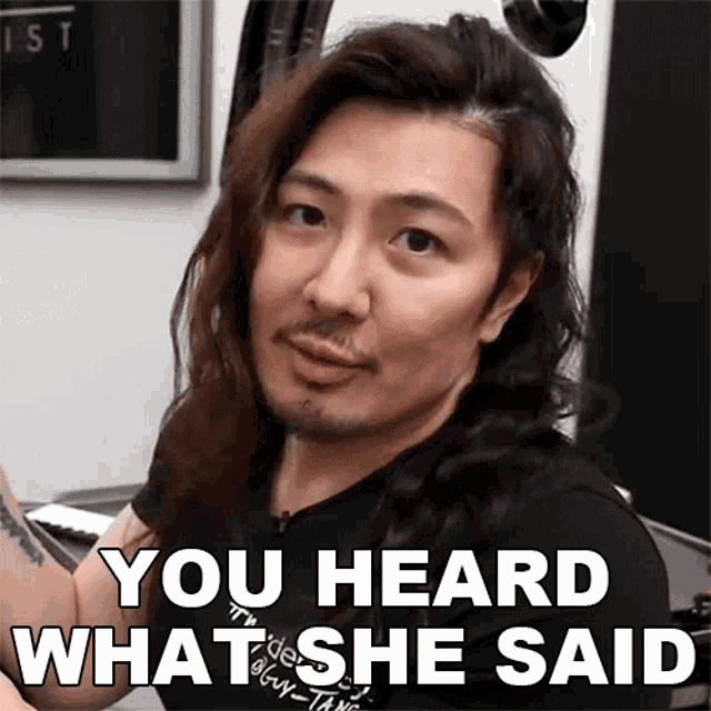 a man with long hair and a beard has the words " you heard what she said " on his face