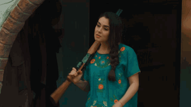 a woman in a blue dress is holding a stick in front of a sign that says ' some coin ' on it