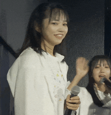 a girl in a white shirt holds a microphone in her hand