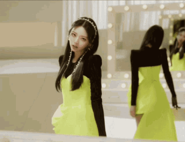 a woman in a bright yellow dress is standing in front of a mirror