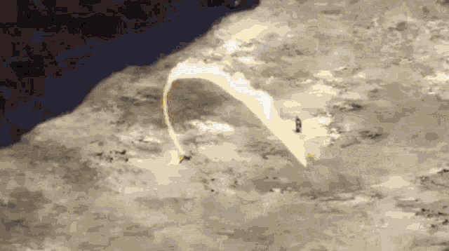 a person is flying a parachute over a rocky cliff
