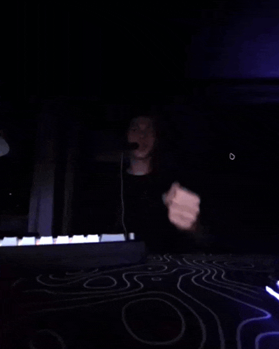 a person giving the middle finger in front of a piano keyboard