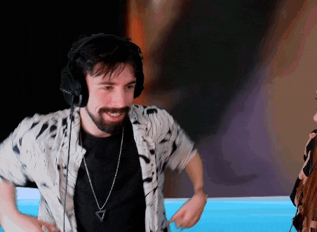 a man with a beard wearing headphones and a triangle necklace