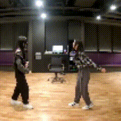 two people are dancing on a wooden floor
