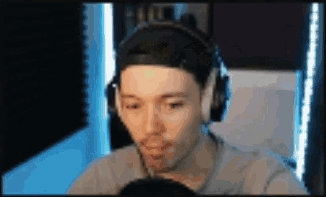 a blurry picture of a man wearing headphones and a baseball cap