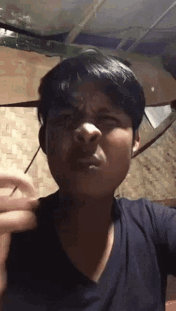 a young man making a funny face with his hand