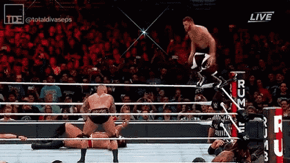 a wrestler is jumping over another wrestler in a wrestling ring during a match .