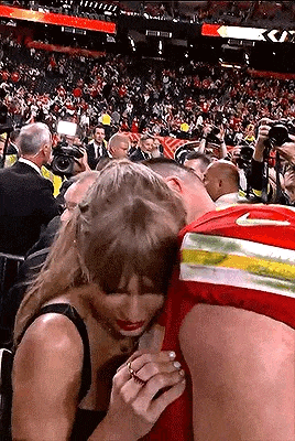 a woman is sitting next to a man in a stadium .