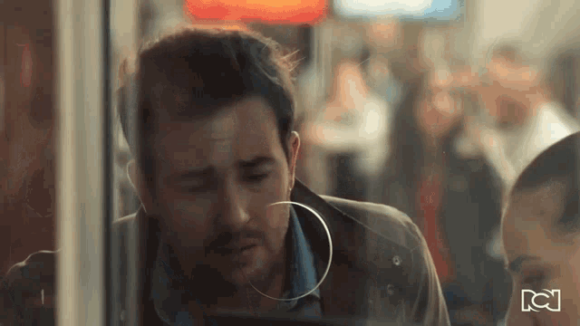a man wearing a hoop earring is looking at his phone