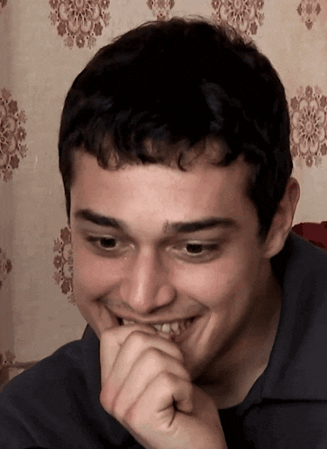 a close up of a man 's face with his hand on his mouth