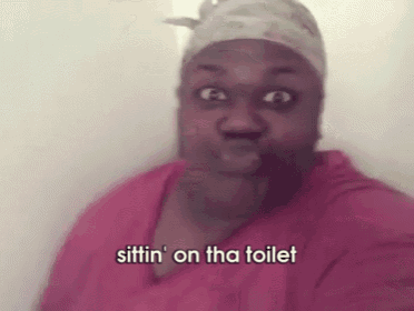 a woman in a pink shirt is sitting on a toilet and making a face .