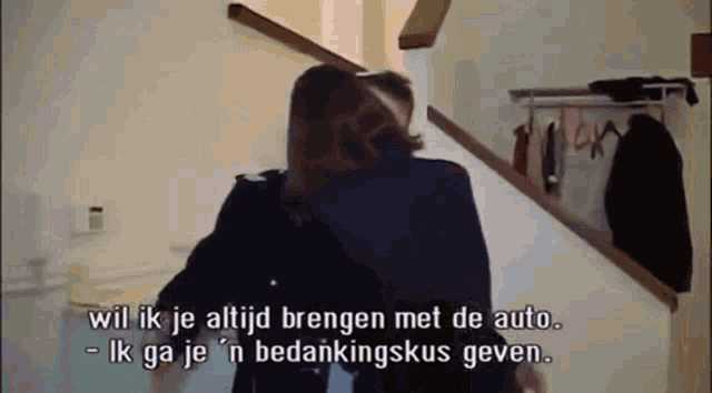 a man and a woman are hugging each other in a room with stairs