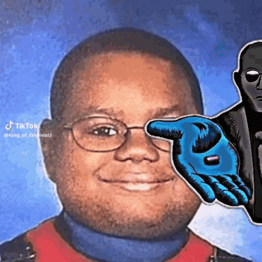 a man with glasses is smiling and holding a blue hand in front of his eye .