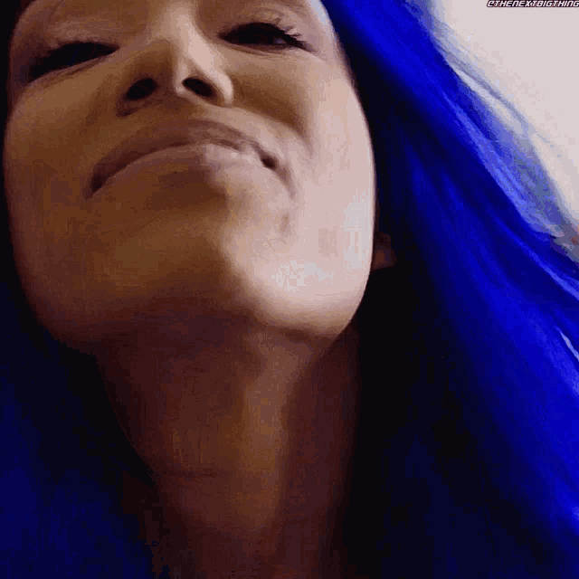 a close up of a woman with blue hair smiling