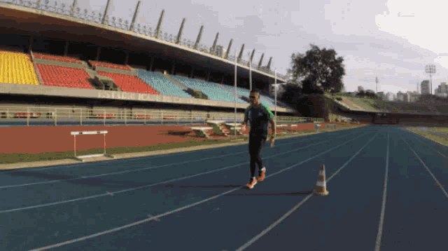 a man is running on a track in front of a stadium that says ' banco do brasil ' on it