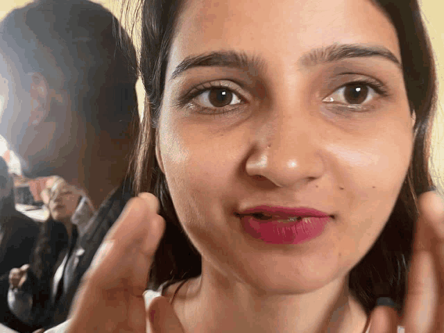 a close up of a woman 's face with her hands in front of her face