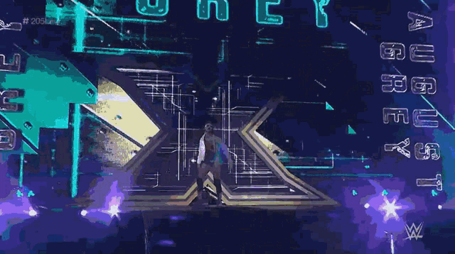 a man in a white shirt is walking on a stage in front of a sign that says ' wwe '