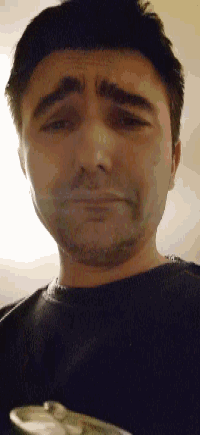 a close up of a man 's face with a black shirt