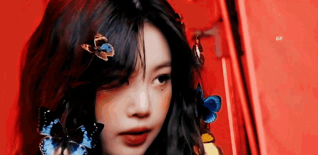 a close up of a woman with butterflies on her hair .