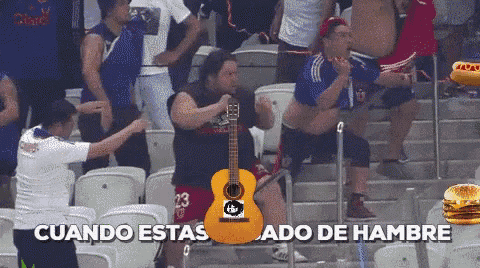 a man sitting in a stadium with a guitar that says cuando estas
