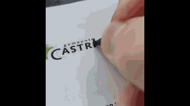 a person is writing on a piece of paper that says castr on it