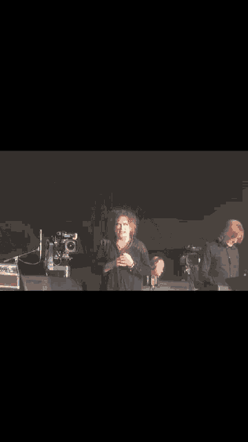 a man with curly hair is standing on a stage
