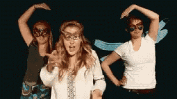 three women wearing masks and sunglasses pose for a picture