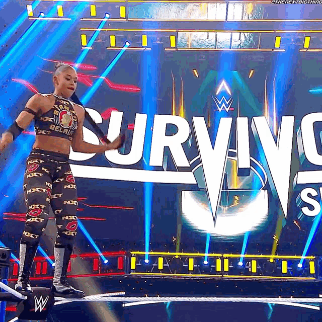 a woman stands on a stage in front of a sign that says survivor 's