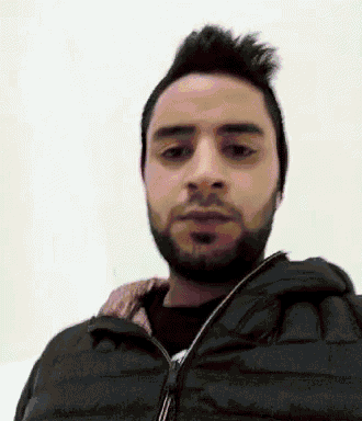 a man with a beard wears a black jacket