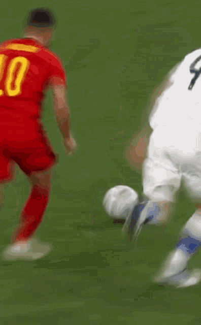 a soccer player with the number 10 on his shirt is being tackled by another player