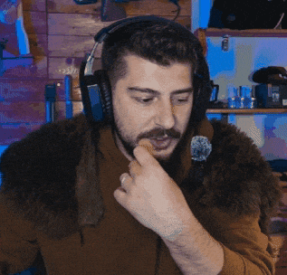 a man wearing headphones and a fur collar looks at something